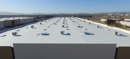 Aerial view of a large commercial warehouse roof with ventilation units.