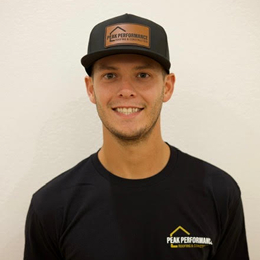 Young man wearing Peak Performance shirt and hat, smiling